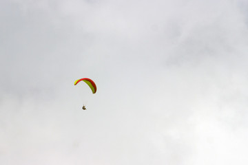 A sportsman flies in the sky in a good suit on a paraglider. Paragliding Sport Concept