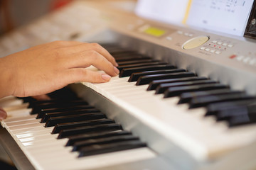 Fototapeta premium Close-up of a music performer's hand playing the piano