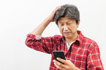 スマートフォンを見て困った顔をする男性