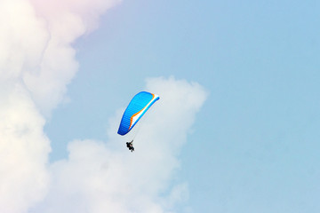 A sportsman flies in the sky in a good suit on a paraglider. Paragliding Sport Concept
