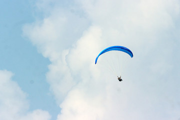 A sportsman flies in the sky in a good suit on a paraglider. Paragliding Sport Concept