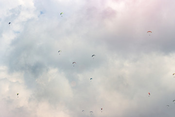 A group of sportsmen flies in the sky in a professional suit on a paraglider. Paragliding Sport Concept for advertising