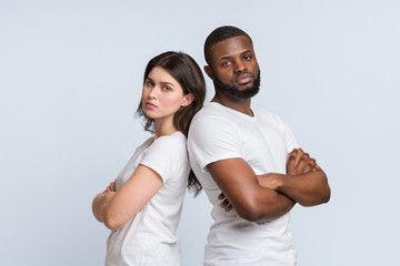 Obraz premium Unhappy multiracial couple standing back to back after conflict