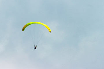 A sportsman flies in the sky in a good suit on a paraglider. Paragliding Sport Concept