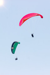 A group of sportsmen flies in the sky in a professional suit on a paraglider. Paragliding Sport Concept for advertising