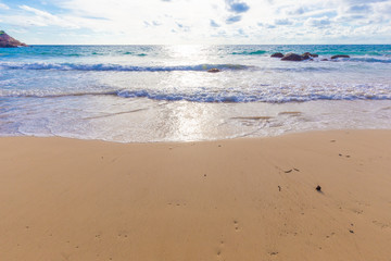 Beautiful sea wave on sandy beach evening sunset light