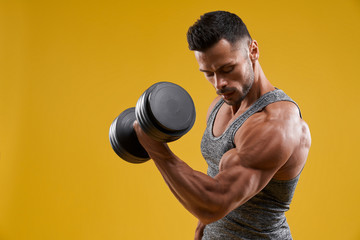 Muscular young man pumping up biceps