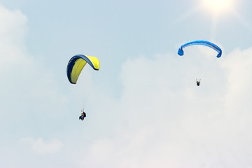 A group of sportsmen flies in the sky in a professional suit on a paraglider. Paragliding Sport Concept for advertising