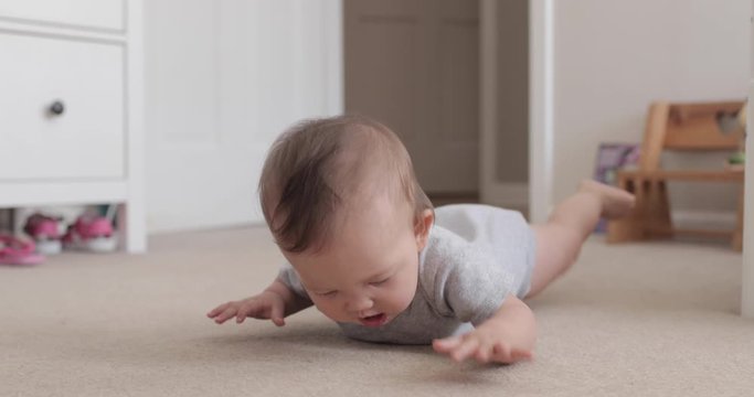 Baby Laying of Floor Trying to Learn How to Crawl