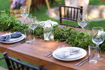 Preparing for an open-air party. Decorated with fresh flowers served tables. Table number. Decoration Details