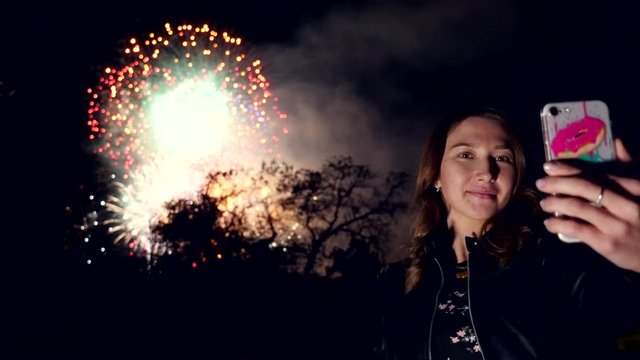 SLOW MOTION: Portrait of a Girl use smart phone, image of firework background