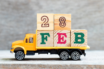 Truck hold letter block in word 28feb on wood background (Concept for date 28 month february)