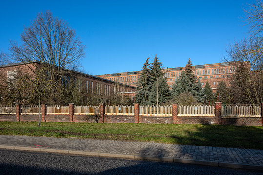 Germany, Saxony-Anhalt, Vockerode: Street view of big old defunct shut down former Vockerode lignite power plant building with brick stone facade, no chimneys and blue sky - concept energy lost place