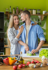 Happy just married couple cooking vegan food at home