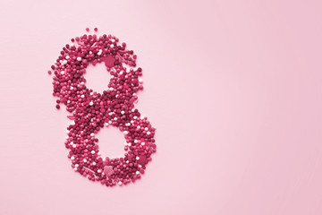 Number 8 in the shape of sweets. March 8 International Women's Day pink background, copy space, flat lay. Beauty background 8 march