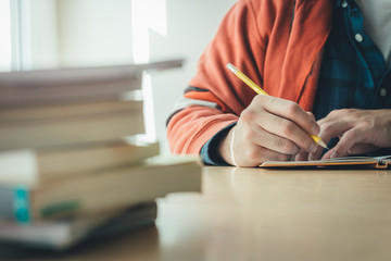 high school,university student study.hands holding pencil writing paper answer sheet.sitting lecture chair taking final exam attending in examination classroom.concept scholarship for education abroad