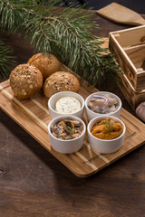 various dip sauces and appetizer and bread bun on wooden table