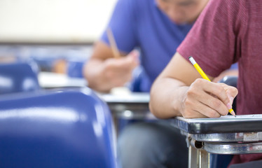 high school,university student study.hands holding pencil writing paper answer sheet.sitting lecture chair taking final exam attending in examination classroom.concept scholarship for education abroad
