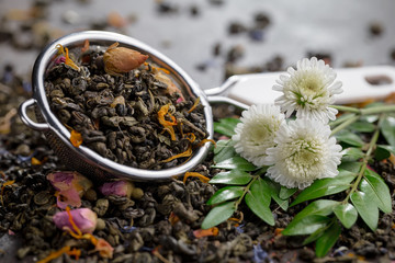 Dry tea leaves in a spoon, on an old background 
