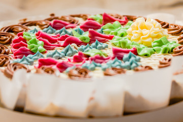 Opened Traditional Kiev Whole round cake with hazelnuts and butter cream top view. Nut cake in packaging, delicious dessert. Close-up. Holiday and festive food concept
