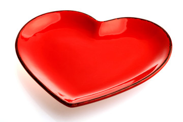A red heart shape plate isolated on white background. Decoration for Valentine's day, wedding,...
