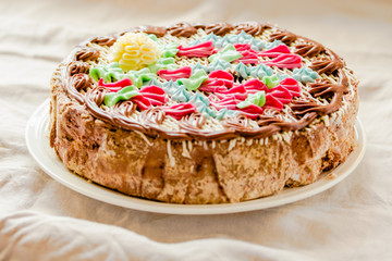 Traditional Kiev(Kyiv) cake or daquoise meringue a piece of cake with butter cream on plate. Tasty holiday cake on a comfort linen white background.