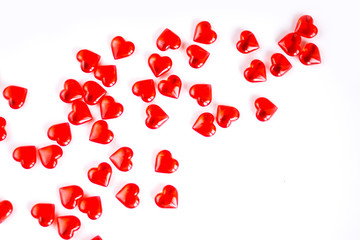Valentine's Day holiday celebration concept. Red glass hearts arranged in random order on a white background. Layout with place for your text.