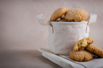 homemade biscuits in a linen basket on a beige background. cracked cookies. Healthy sweets cooking for family.