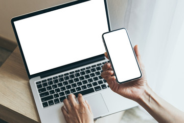 mockup image blank screen computer,cell phone with white background for advertising text,hand woman using laptop texting mobile contact business search information on desk in cafe.marketing,design