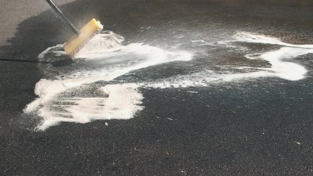 Rinse of Oil Spots Cleaned with Foam Soap on Driveway with Hose of Water, 4k