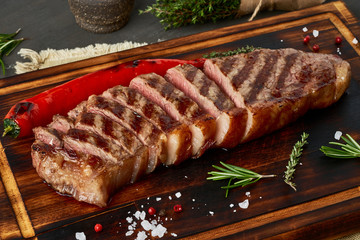 Keto ketogenic diet medium beef steak, grilled striploin on cutting board. Paleo food recipe with meat