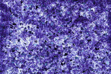 Abstract background of close up detail of fragments of purple crushed glass 