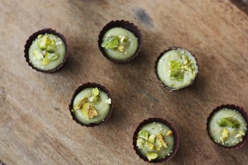 Delicious chocolate candies with pistachios on the table