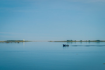 Rocky sea coast shoreline with distant lighthouse.