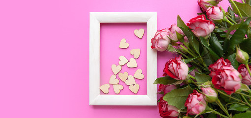 Wooden hearts and roses on a pink background with copy space for text. Banner for Valentine's Day