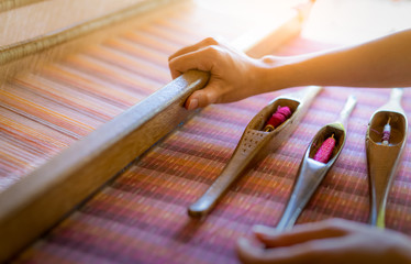 Woman working on weaving machine for weave handmade fabric. Textile weaving. Weaving using...