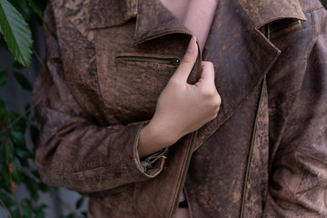 Partial view of woman wearing brown leather jacket