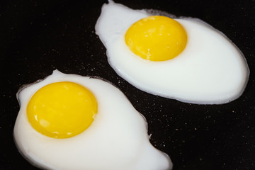 Raw fried eggs.Tasty over easy fried egg in frying pan, closeup