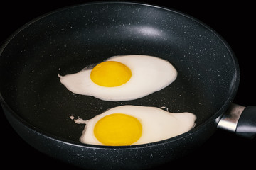 Raw fried eggs.Tasty over easy fried egg in frying pan, closeup