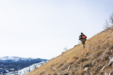 Man hiking in mountains hunting for birds, USA