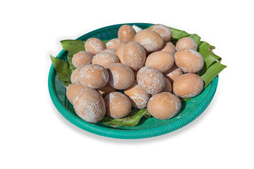 Salt pickled eggs on the banana leaf in the green plastic basket.