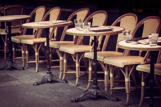 Empty retro tables and chairs on a outdoor cafe terrace in Paris, France