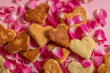  Valentine cookies are in rose petals on a pink background