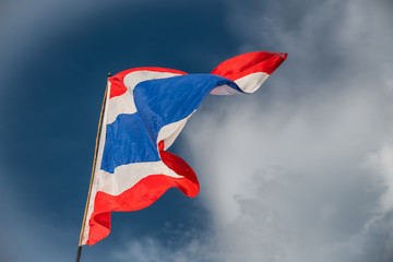 Waving flag of Thailand against blue sky