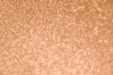 Abstract Christmast golden pink bokeh background with shining defocus sparkles. Blurred glitters shimmering dust macro close up, copy space for text logo