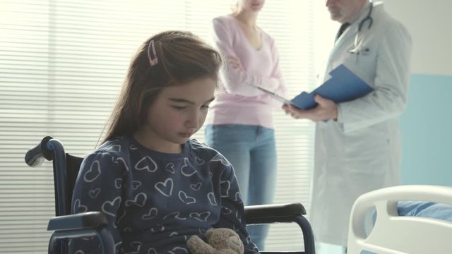Girl in wheelchair using a digital tablet at the hospital