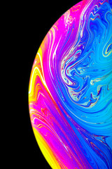 Close up macro photograph of the psychedelic rainbow of colors mixing and swirling in a soap bubble...