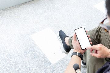 Mockup image blank white screen cell phone.man hand holding texting using mobile sitting at coffee shop.background empty space for advertise text.people contact marketing business,technology 