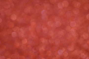Abstract New Year coral bokeh background with shining defocus sparkles. Blurred glitters shimmering dust macro close up, copy space for text logo