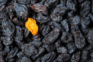 yellow raisins lying on the black raisins
